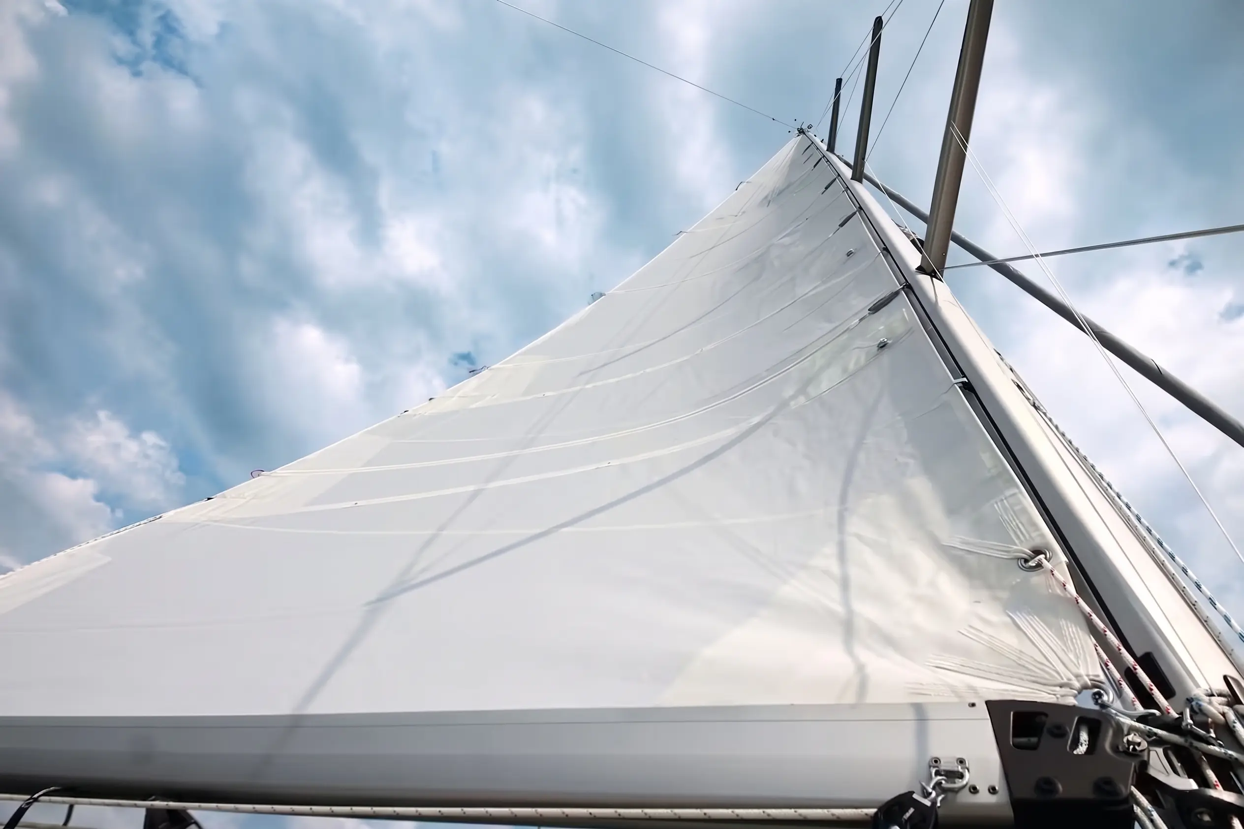 Mainsail viewed from the deck beneath a bright sky