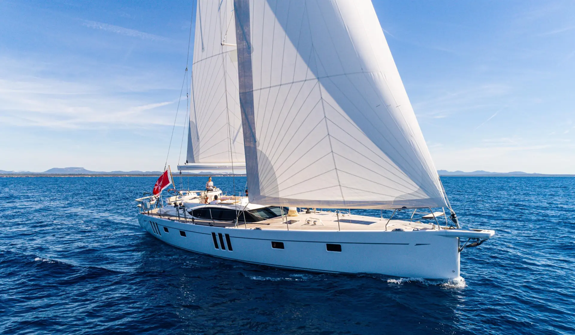 Performance cruising yacht sailing with a shaped headsail