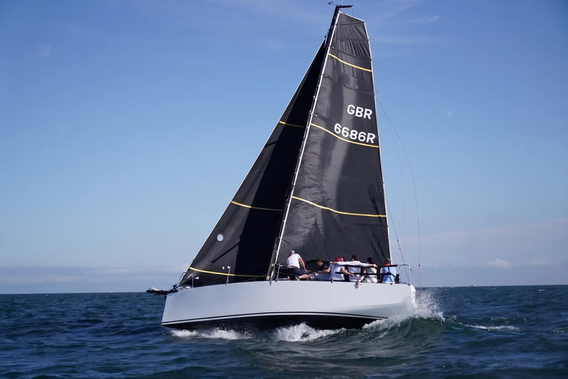 White sail number and country code applied to a black mainsail