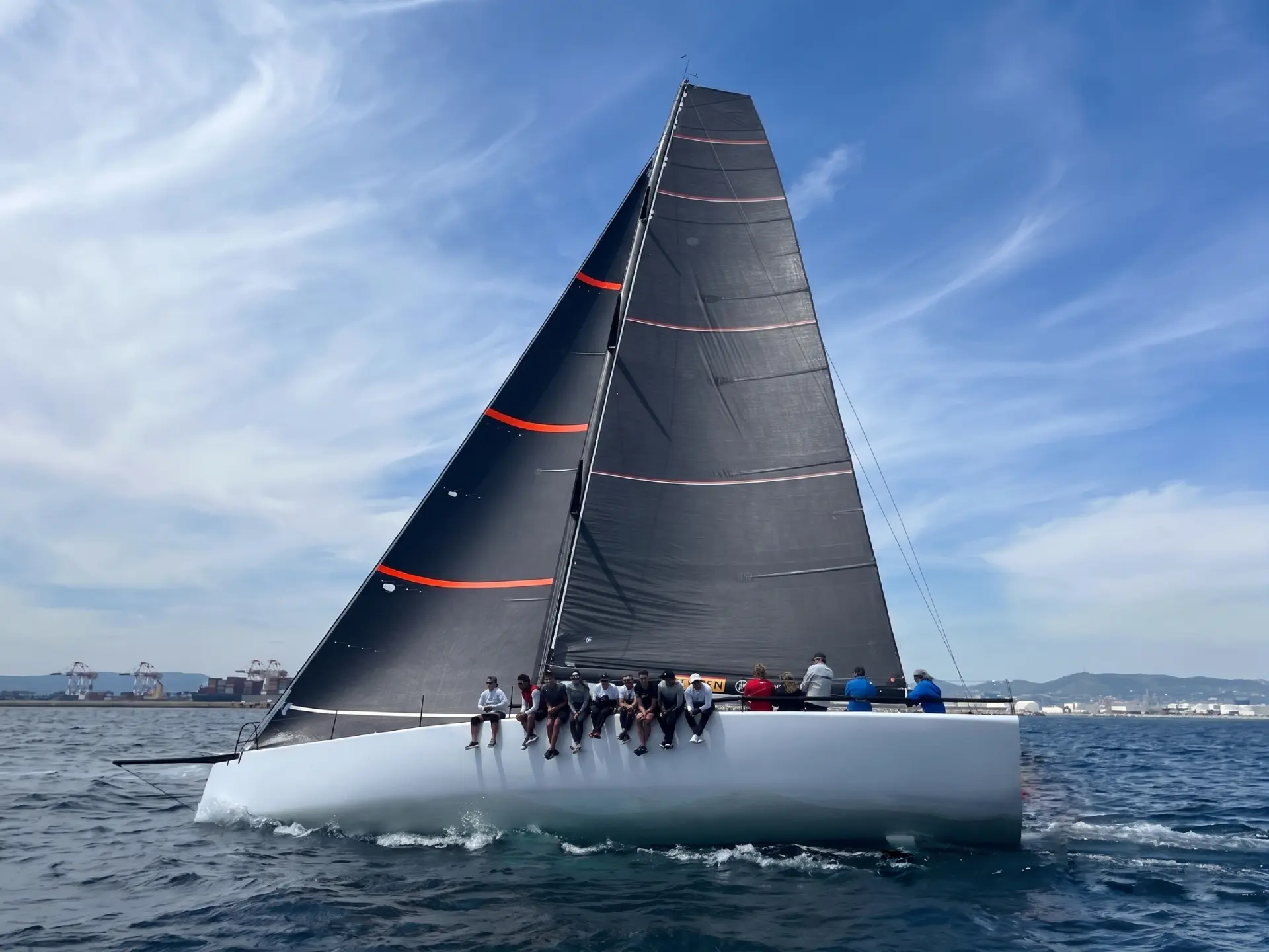 Racing yacht sailing with a high-roach black mainsail
