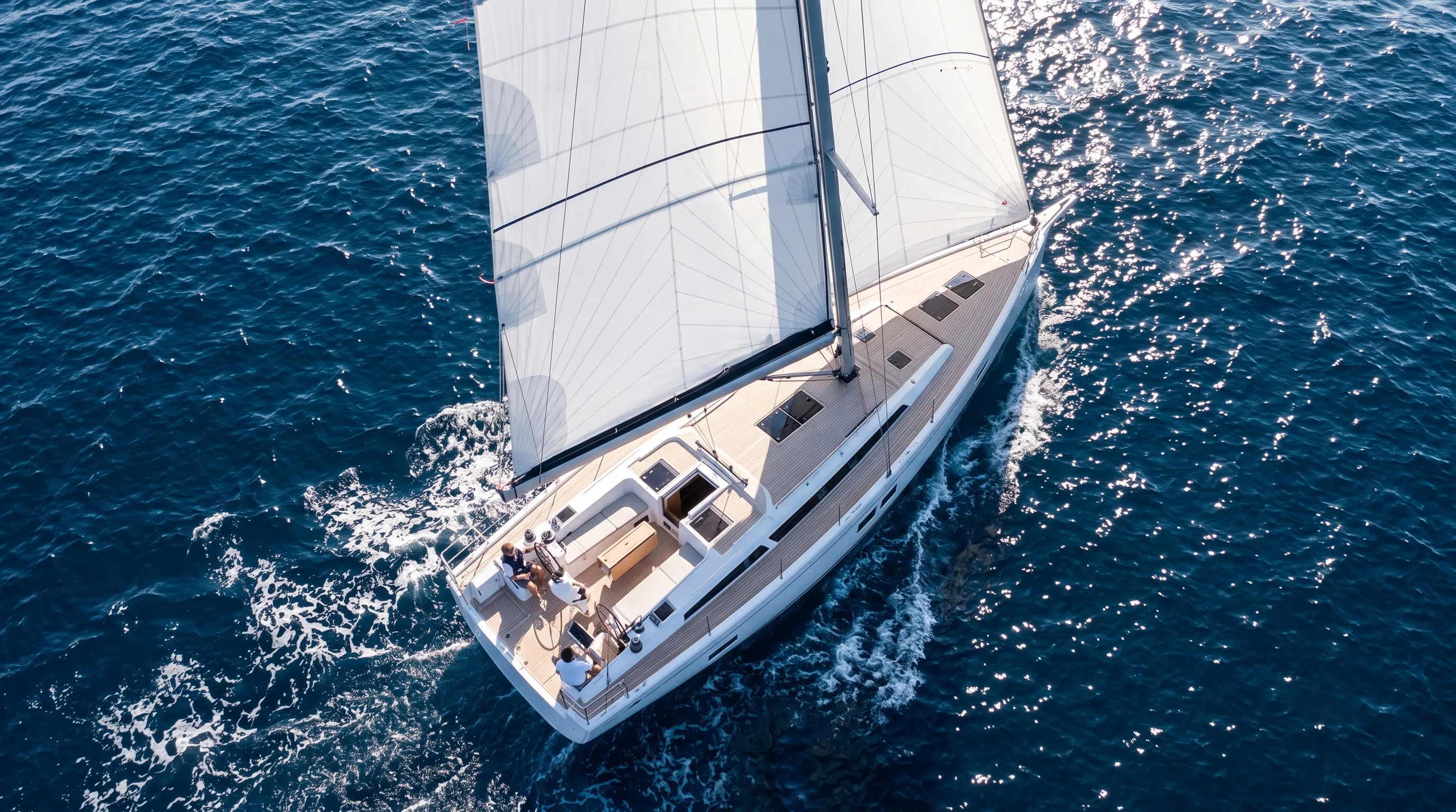 Aerial view of a cruising yacht under white sails