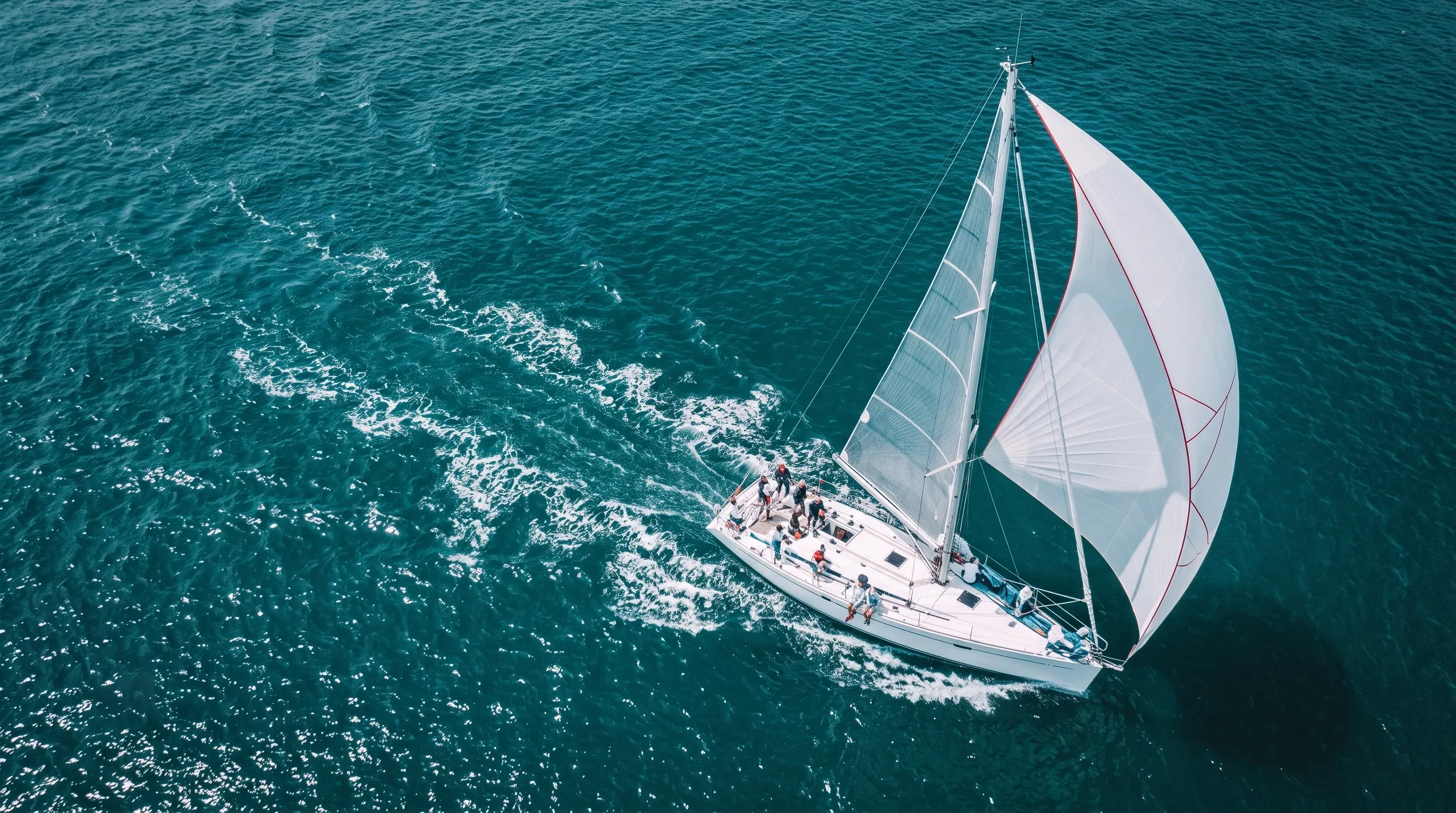 Aerial view of a sailing yacht flying a spinnaker