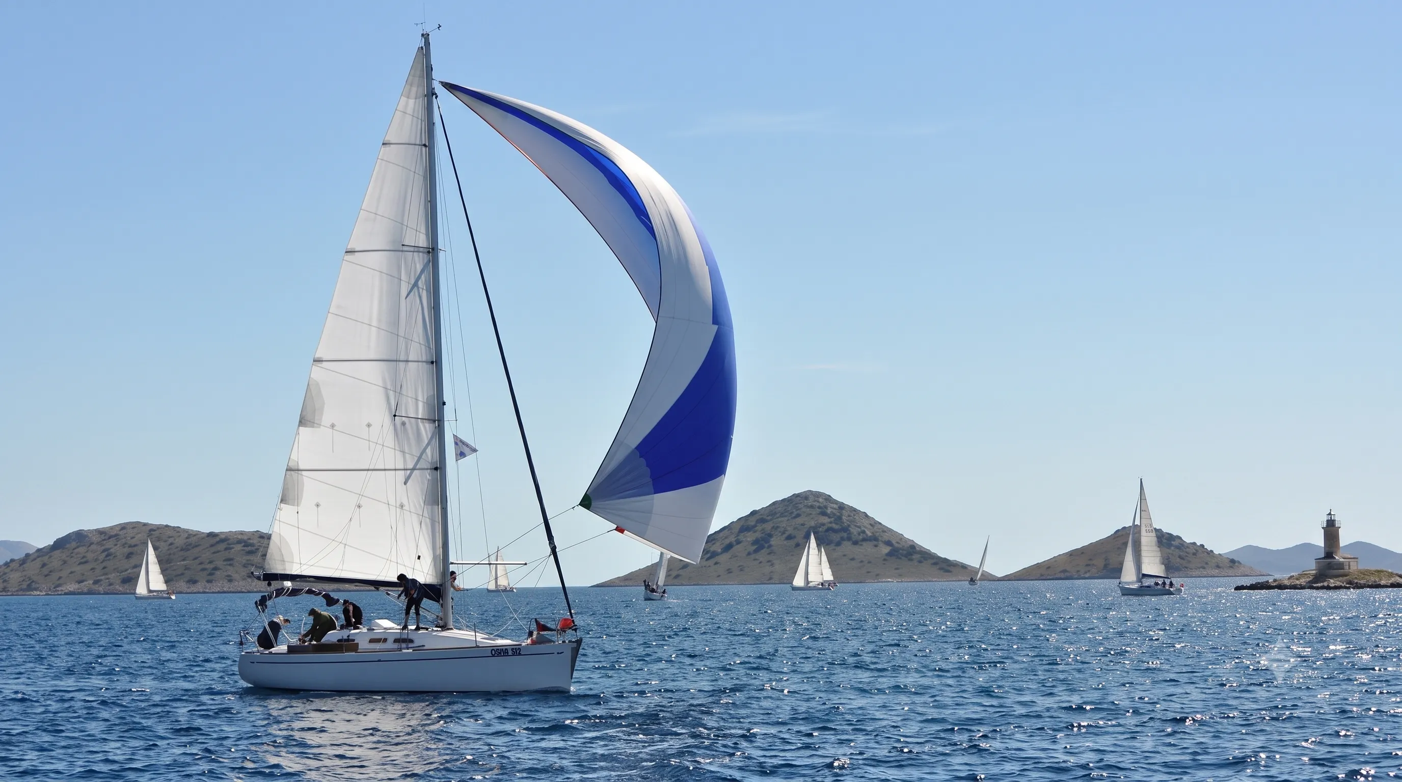 Blue and white spinnaker flying beside a racing yacht